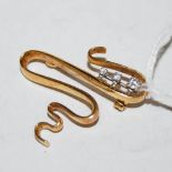 An 18ct gold and diamond three stone brooch, of scroll form set with graduated row of three round