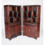 A pair of Chinese carved darkwood display cabinets, early 20th century, a staggered arrangement of