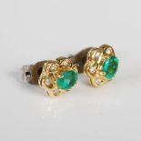 A pair of 18ct gold, emerald and diamond cluster earrings. each set with an oval faceted emerald