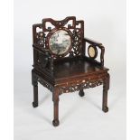 A Chinese carved darkwood and inlaid armchair, Qing Dynasty, the shaped back rail with two carved