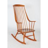 An Ercol rocking chair, in the Windsor style with elongated back with straight back rail and curving