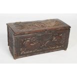 A late 17th century carved oak coffer, the front board carved with a pair of dragons issuing leafy