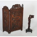 A 20th century South Asian carved fire screen, the central panel with a figure of a dragon with a