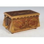 An Arts & Crafts brass inlaid mahogany casket, of sarcophagus form with two curving handles to