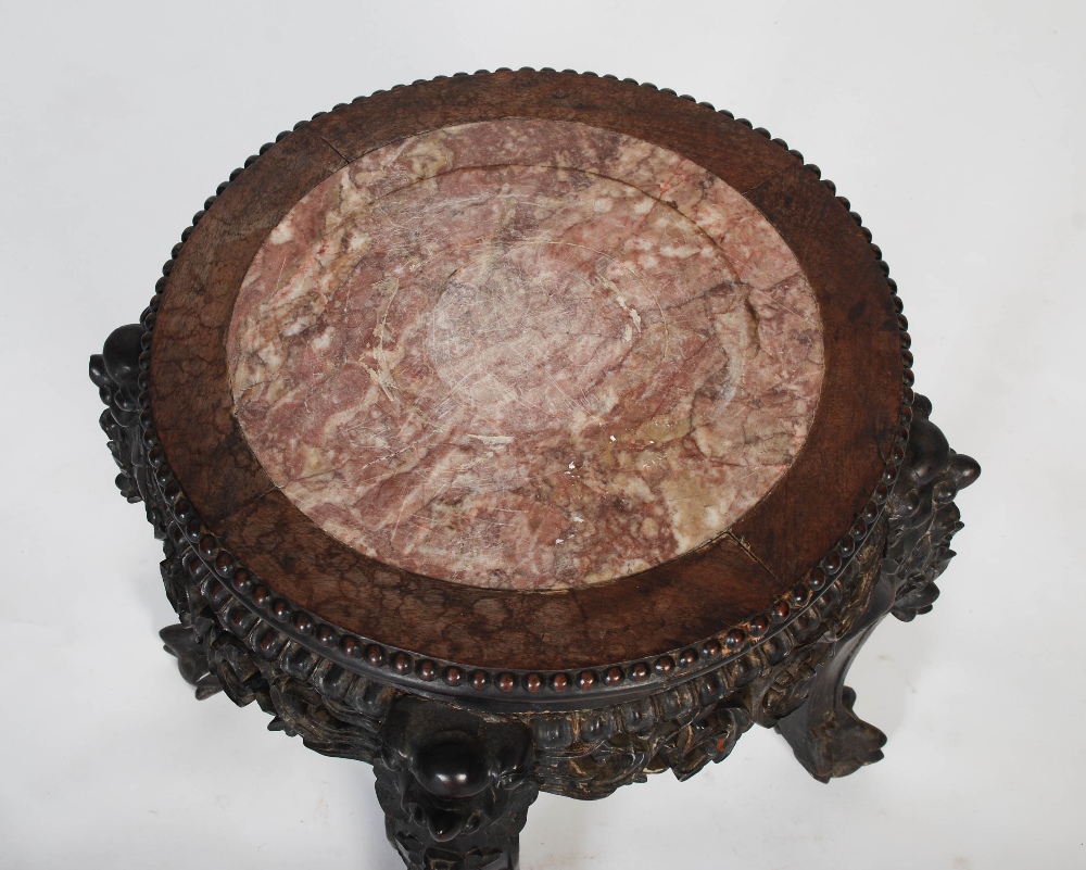 A Chinese carved darkwood stand, Qing Dynasty, the round top inset with marble, over carved and - Image 2 of 4
