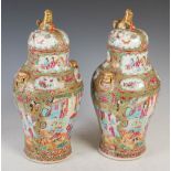 Pair of Chinese porcelain famille rose Canton jars and covers, Qing Dynasty, decorated with panels