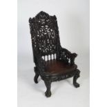 A Chinese carved darkwood armchair, Qing Dynasty, the back rail richly carved in relief with two