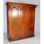 A late 19th century mahogany triple section wardrobe, with a rectangular cavetto pediment atop three