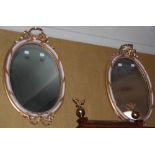 A pair of 20th century gilt gesso oval mirrors, the frames with inner gilt beaded rim and white