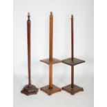 Three 20th century standard lamps, two of square form with central occasional table shelf to the
