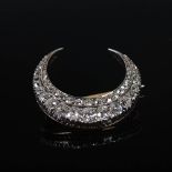 A yellow and white metal diamond set crescent brooch, set with two rows of graduated old cut and