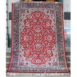 A machine made Keshan wool carpet, the madder ground with all over foliate design within a blue