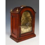 A 20th century mahogany bracket clock, the case of arched form with finials and a handle, the