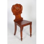A 19th century mahogany armorial hall chair, the shaped back with gadrooned swag mouldings, the wood