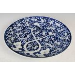 Japanese blue and white porcelain charger, late 19th/ early 20th century, decorated with prunus tree