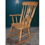 A 20th century beech Windsor style rocking chair, with pierced vase-shaped centre back splat, curved