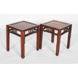 A pair of Chinese darkwood low tables, Qing Dynasty, the rectangular tops with recessed panels,