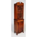 An early 20th century mahogany and walnut bookcase, the top with oval glazed door with two glass