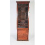 A 19th century mahogany bookcase / estate cabinet, topped by a pediment with carved roundels over