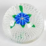 A limited edition Perthshire Paperweight, centred with a blue twelve petal flower on a latticino