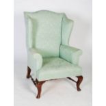 A 20th century wing backed armchair, upholstered in mint green damask style fabric on two short