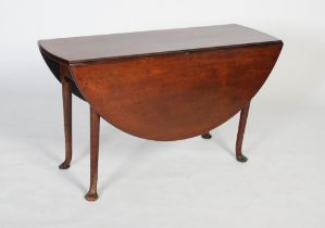 A George II mahogany dining table, circa 1740-60, the oval drop leaf top on four cabriole legs