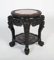 A Chinese carved darkwood stand, Qing Dynasty, the shaped round top carved with a frieze of