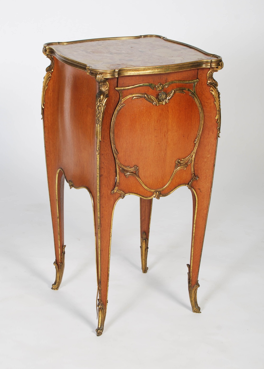 An early 20th century French oak and gilt bronze mounted marble topped bedside table in the manner