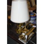 An early 20th century brass oil lamp, converted to electric fitting with an oval cream shade, 51cm
