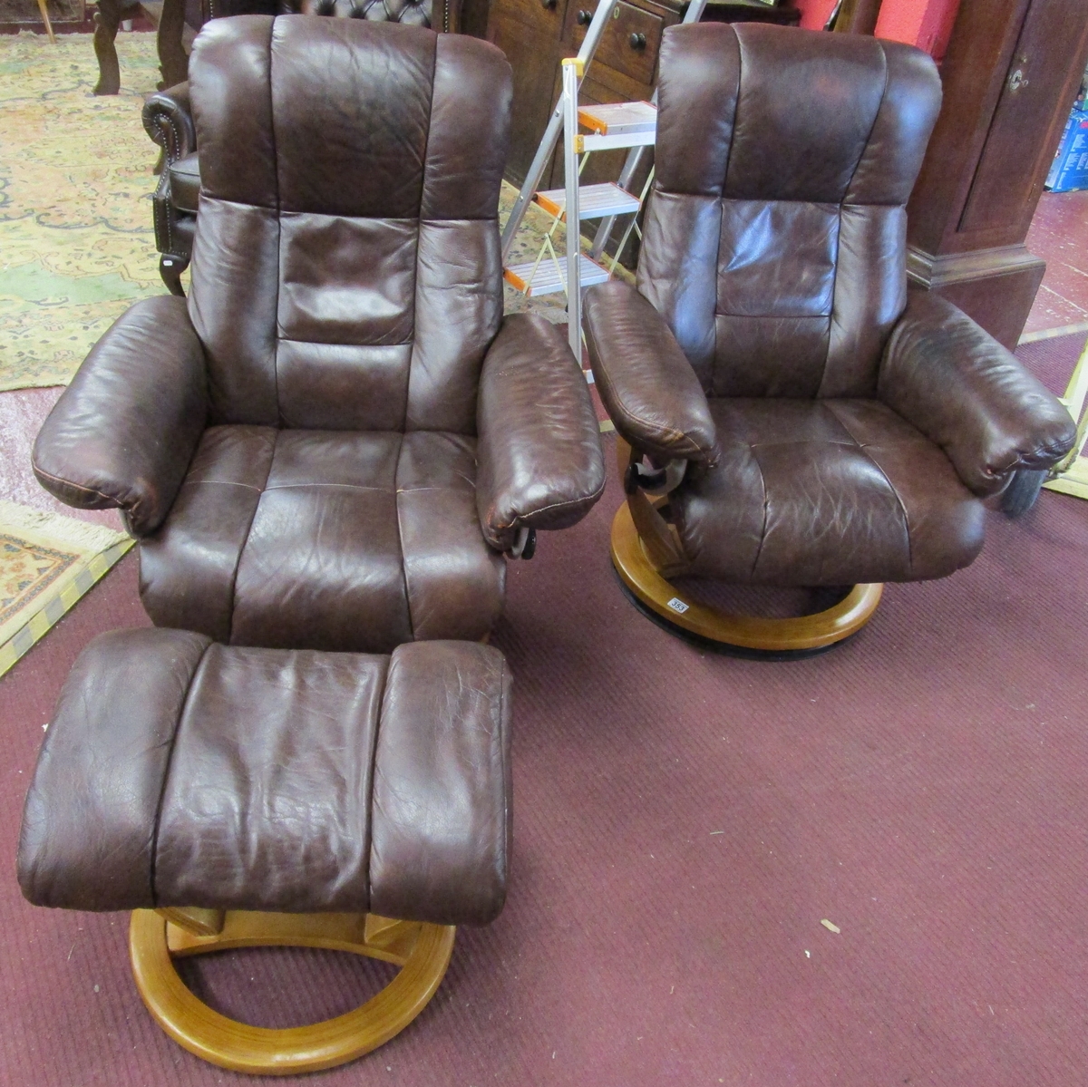 Pair of Stressless style leather reclining and swivel armchairs with stool