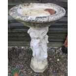 Stone bird bath adorned with ladies