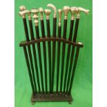 Collection of white metal tipped walking sticks displayed in stand
