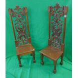 Pair of ornately carved tall chairs depicting dragons