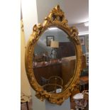 Gilt framed oval mirror depicting cherubs