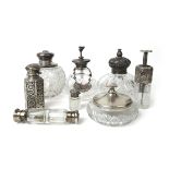 A collection of silver and white metal topped cut glass scent bottles and pots to include a double