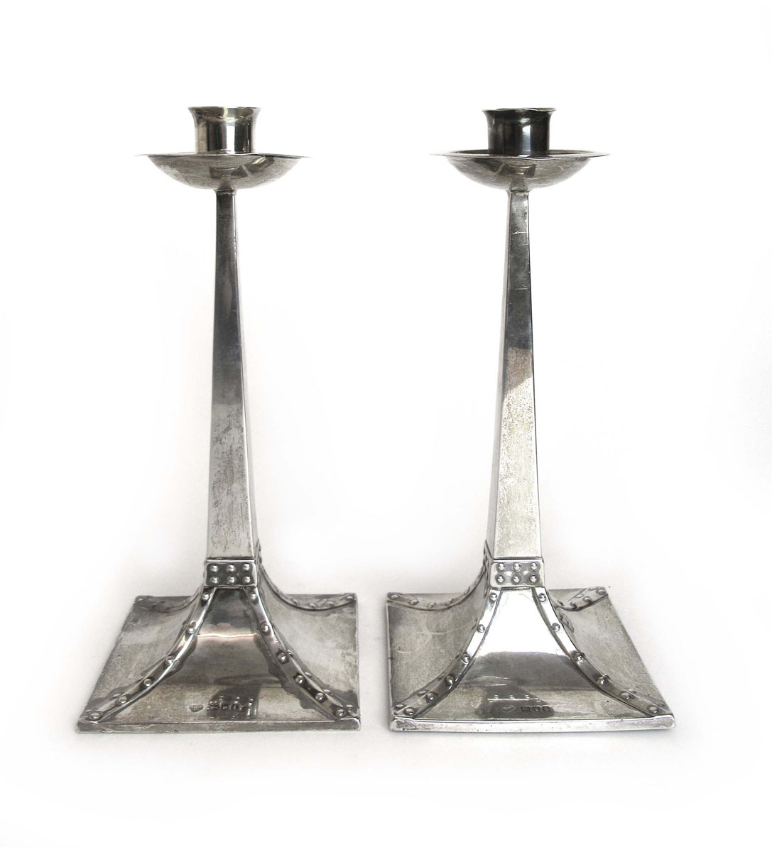 A pair of Edwardian Arts and Crafts silver candlesticks,