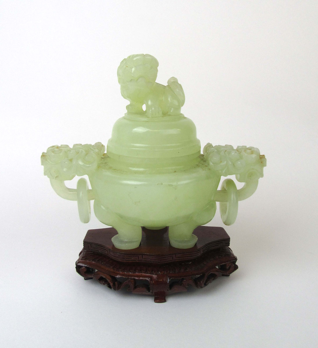 A 20th century Chinese jade censor having mythical beast mask handles and a Foo dog finial.