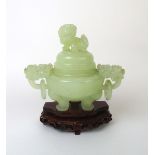 A 20th century Chinese jade censor having mythical beast mask handles and a Foo dog finial.