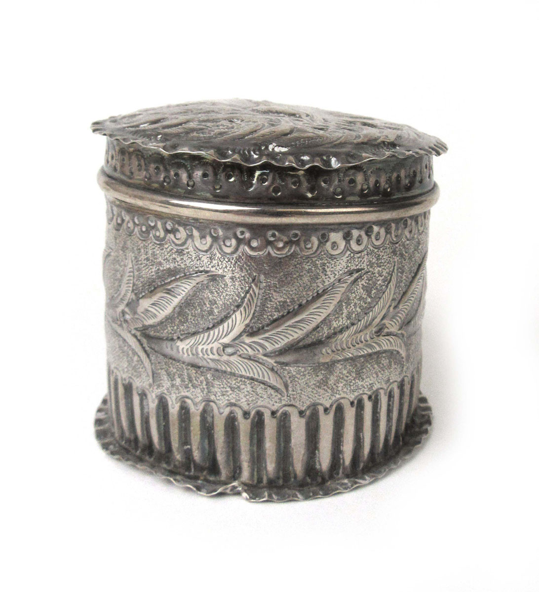 A small Victorian silver tea caddy having embossed naturalistic decoration.