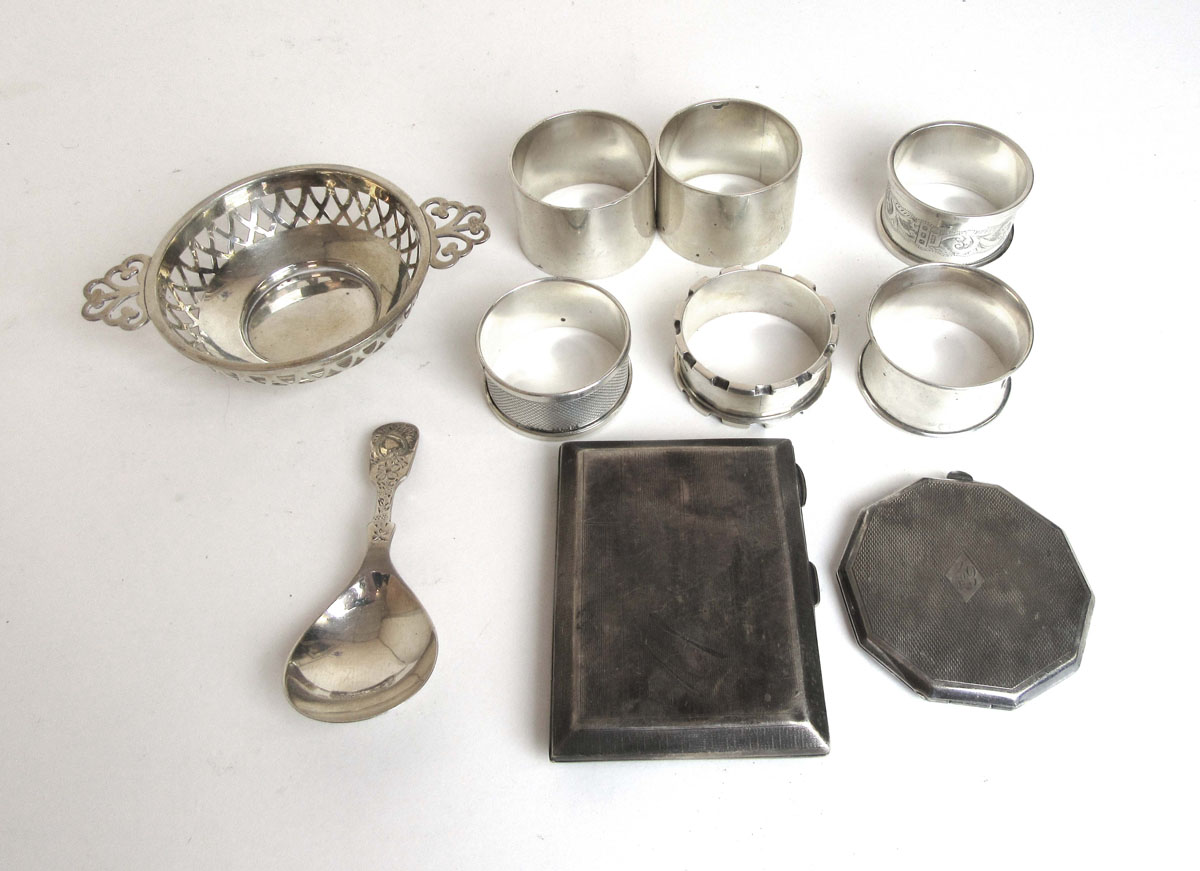 An assortment of silver items to include napkin rings, cigarette case, caddy spoon etc.