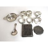 An assortment of silver items to include napkin rings, cigarette case, caddy spoon etc.
