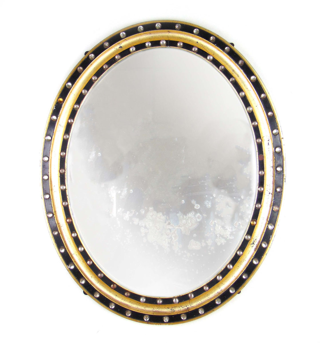 An early 20th century ebonized and parcel gilt oval mirror,