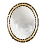An early 20th century ebonized and parcel gilt oval mirror,