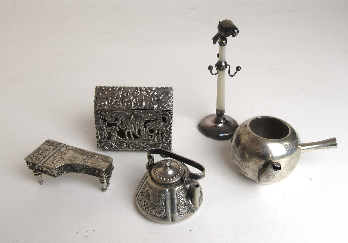 A collection of miniature silver and white metal items to include a bureau (a/f), piano, kettle,