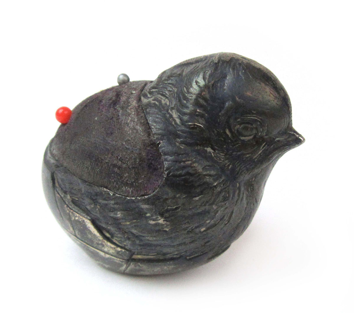 An Edwardian silver pin cushion in the form of a chick.