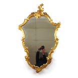 A 19th century rococo giltwood mirror, the floral scrolling asymmetric frame with beveled plate,