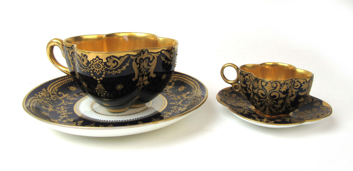 An early 20th century Coalport quatrefoil shaped cabinet cup and saucer having gilt decoration on a