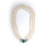 A triple strand continuous cultured pearl necklace with an 18ct white gold clasp set with emeralds