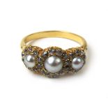 A Victorian pearl and diamond cluster ring, the three graduated pearls surrounded by old cut stones.