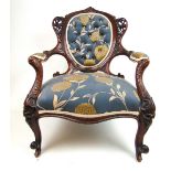 A late 19th century walnut open arm chair,